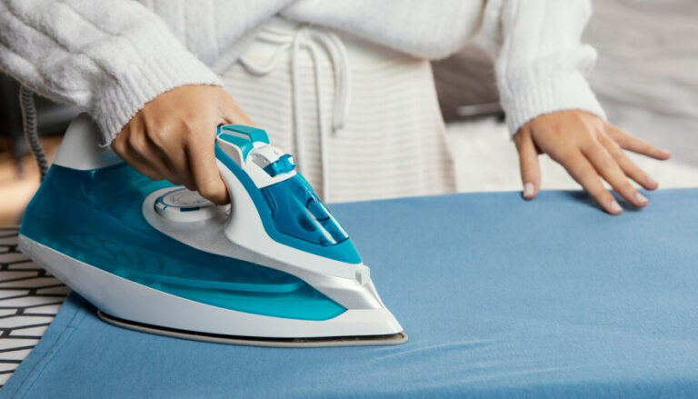 Une personne entrain d'utiliser un fer à repasser