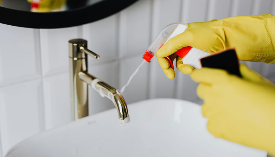 Une personne utilise un produit ménager chimique sur son évier