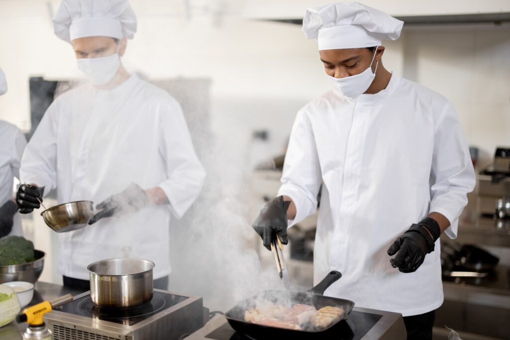 Deux cuisiners en train de préparer un plat à base de sauce fermentée.